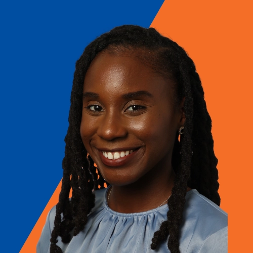 A young black woman, smiling, in a ruched blue shirt on a vivid orange and blue background.